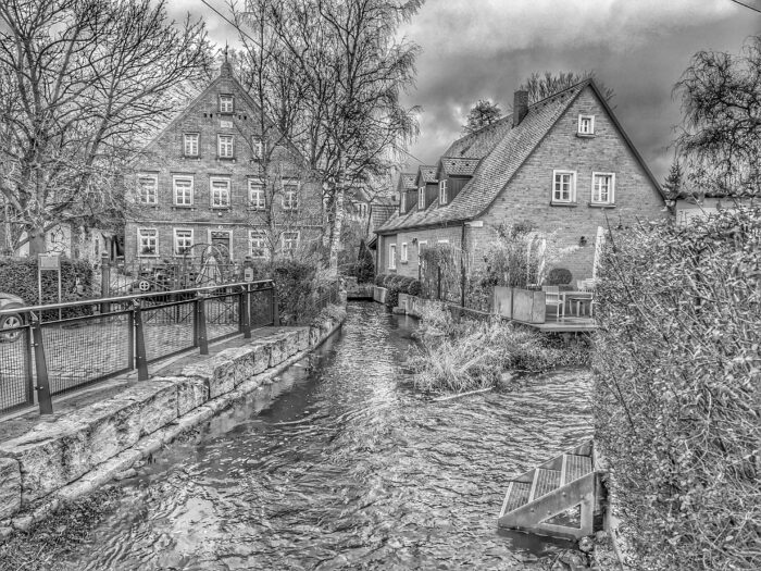 Schmaler Bach, der zwischen historischen Backsteinhäusern mit Giebeln fließt