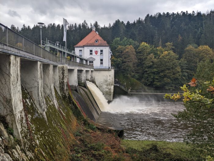 Kraftwerk am Höllenstein der Stadt Straubing mit herabstürzendem Wasser vor bewaldetem Hintergrund