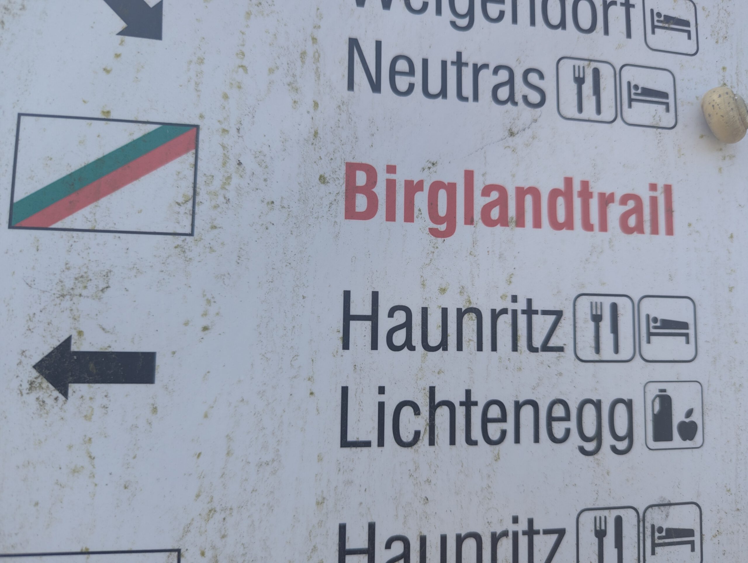 Wegweiser am Birglandtrail nach Neutras, Haunritz und Lichtenegg mit Symbolen für Gastronomie und Übernachtung