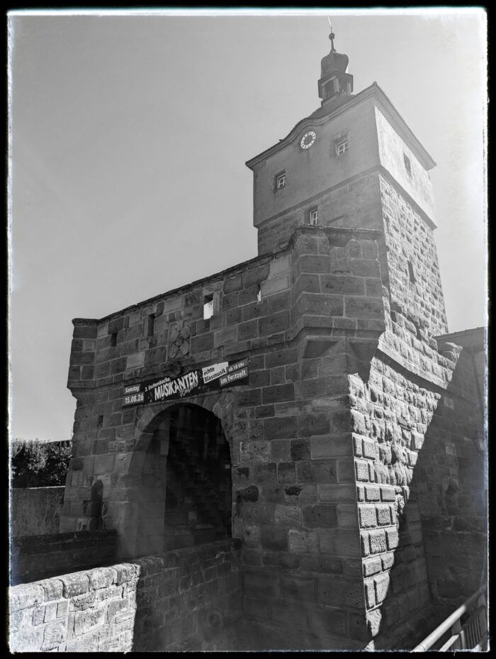 Mittelalterliches Oberes Tor in Wolframs-Eschenbach mit steinernem Torbogen und Uhrturm
