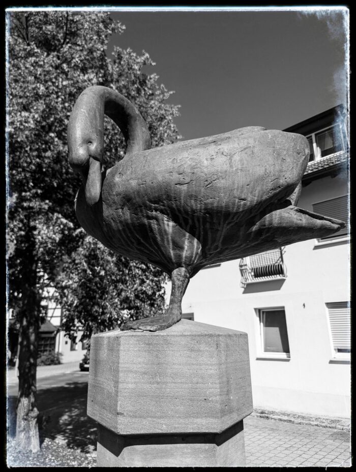 Schwanenskulptur aus Bronze auf einem steinernen Sockel