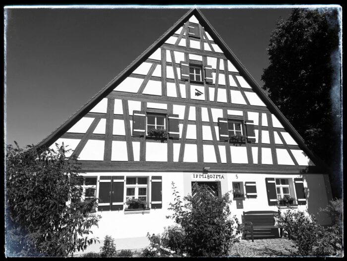 Fränkisches Fachwerkhaus mit steilem Giebel, Fensterläden und Inschrift JPM 1807 MA über der Tür