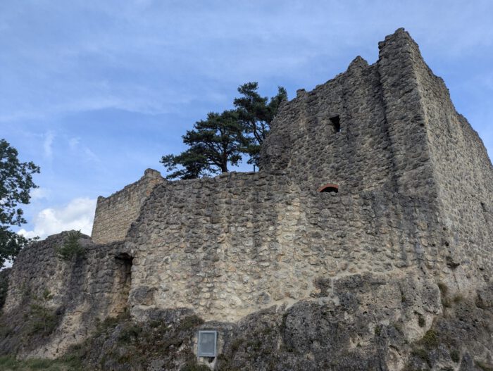 Mittelalterliche Burgruine Lichtenegg aus Naturstein auf einem Felsen unter blauem Himmel