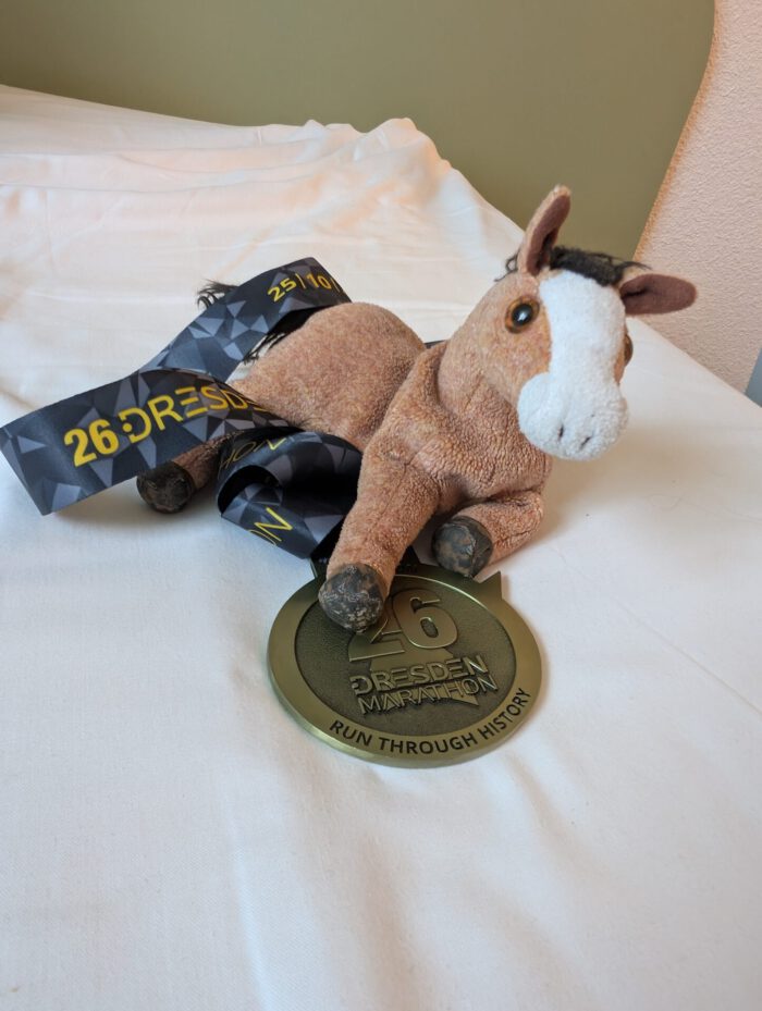 Pferdinand mit der Finisher-Medaille des 26. Dresden Marathons mit der Aufschrift Run Through History